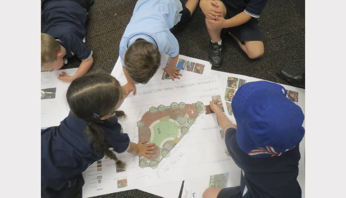 Students from the ASPECT South Coast School pouring over the plans for Luke’s Place, a new inclusive playground.