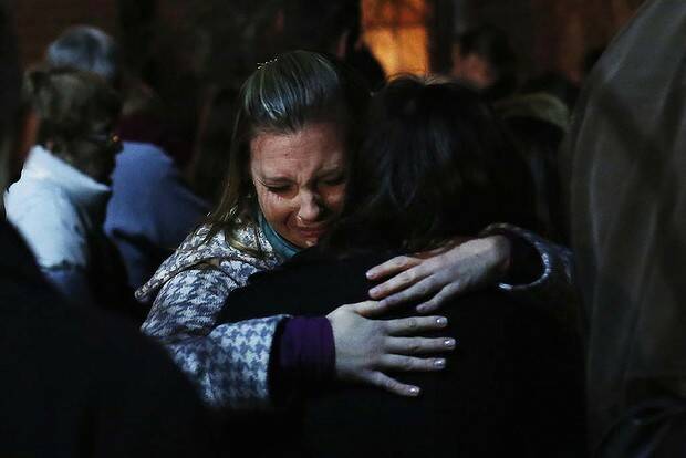 People grieve outside the overflow area of a vigil at the Saint Rose of Lima church in Newtown. Picture: Reuters
