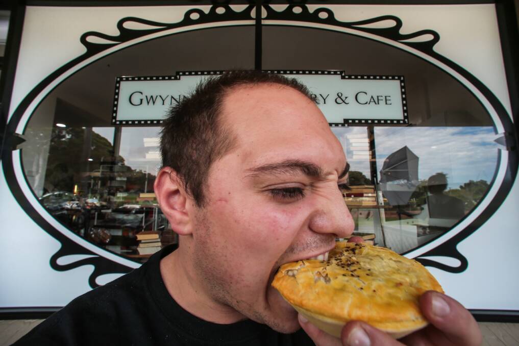 Sam Patrinos of Gwynneville Bakery tucking into a pie. Picture: ADAM McLEAN
