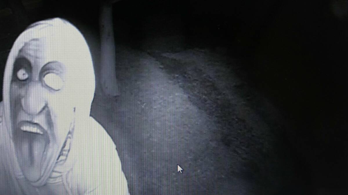 A masked intruder just before he ripped a security camera down from Cr Petty's property at Helensburgh.  