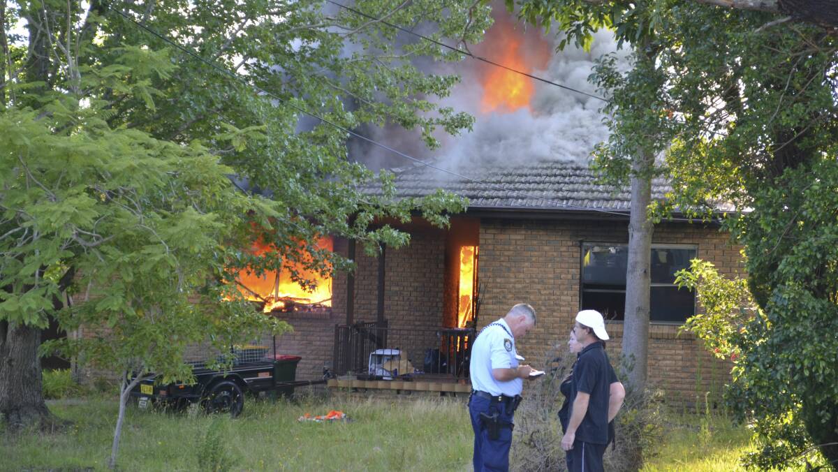 Police begin investigations as the home continues to burn in North Nowra. Pictures: ROBERT CRAWFORD