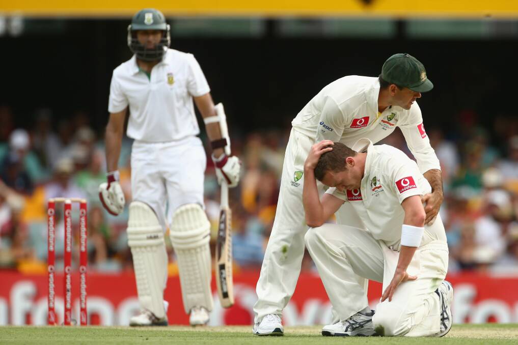 Ricky Ponting helps teammate Peter Siddle to his feet after his dropped catch. Picture: GETTY IMAGES