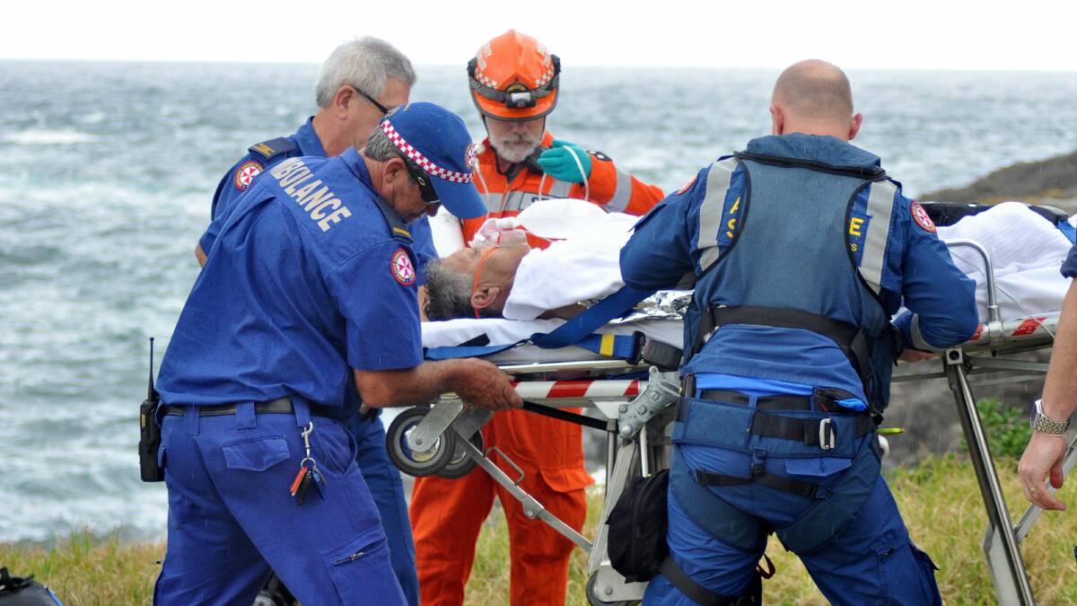 Ambulance officers place the man on a stretcher before transporting him to Wollongong Hospital.