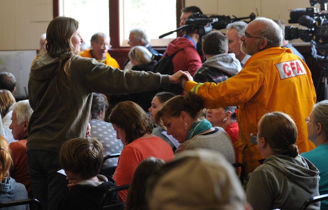 Community meeting at Snake Valley Community hall in the aftermarth of yesterdays fire in Carngham near Ballarat. Locals give firemen a hug. Photo: Wayne Taylor